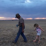 Hay Springs, Nebraska.September 2, 2012..On an evening stroll, Jim Mracek leads his grandaughter across the drought stricken fields of the cattle ranch that he looks after, keeping an eye out for burrs because she is wearing sandals.