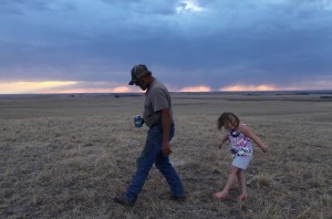 Hay Springs, Nebraska.September 2, 2012..On an evening stroll, Jim Mracek leads his grandaughter across the drought stricken fields of the cattle ranch that he looks after, keeping an eye out for burrs because she is wearing sandals.