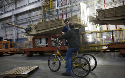 Workers use tricycles to move around the large plant.