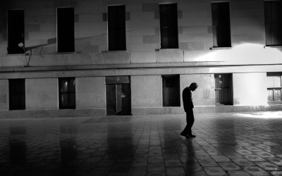 A man walks slowly through Mint Plaza.