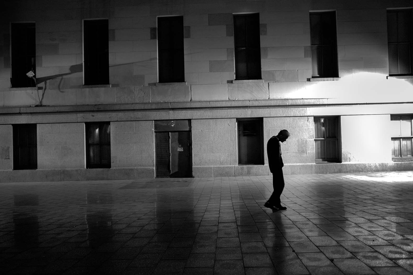 A man walks slowly through Mint Plaza