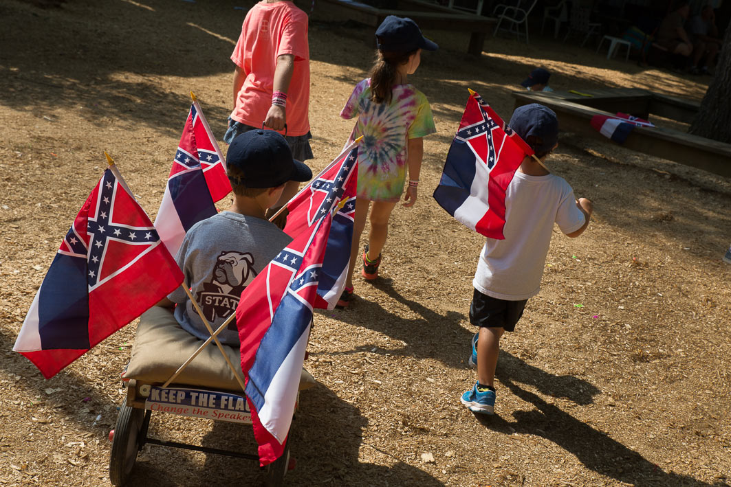 Kids ride a wagon emblazoned with Mississippi Flags during "Political Speaking" on Founders Square at the Neshoba County Fair. 