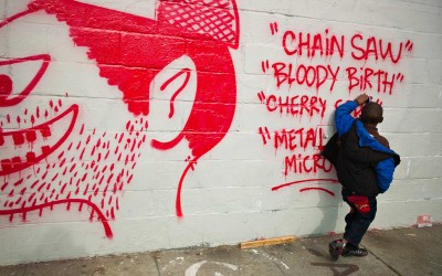 "Chain saw bloody birth." Orlando, 5-years old, plays at the wall. East and West Oakland gangs fight to claim turf and mark their territories with graffiti.